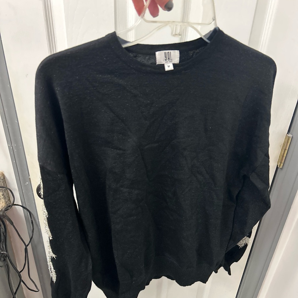 NWOT YAL black sweater with silver design on sleeves.